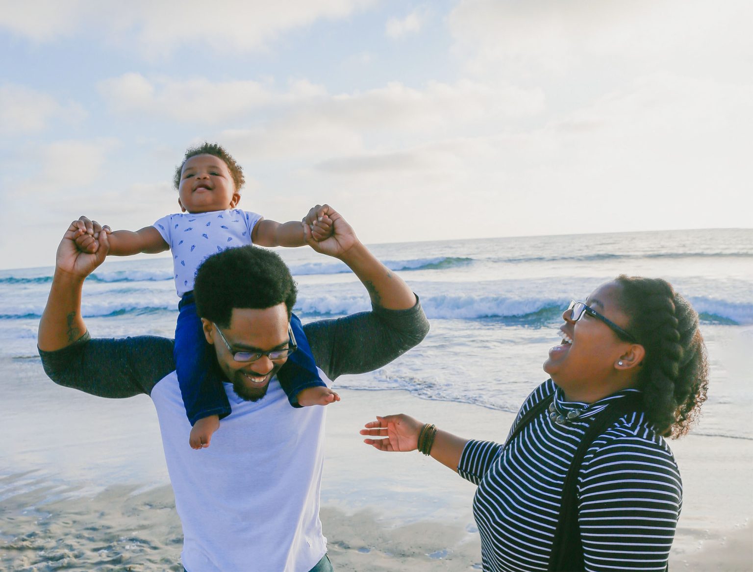 Family with a young child enjoying the beach.