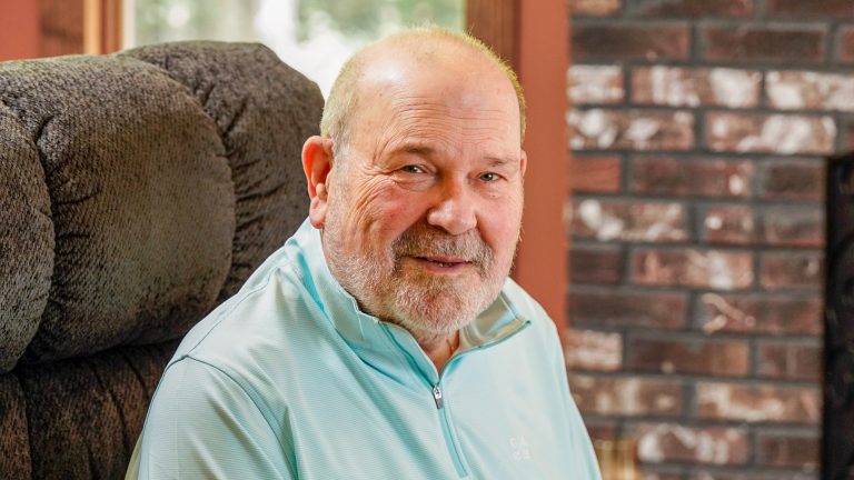 Robert sitting in chair in his living room.