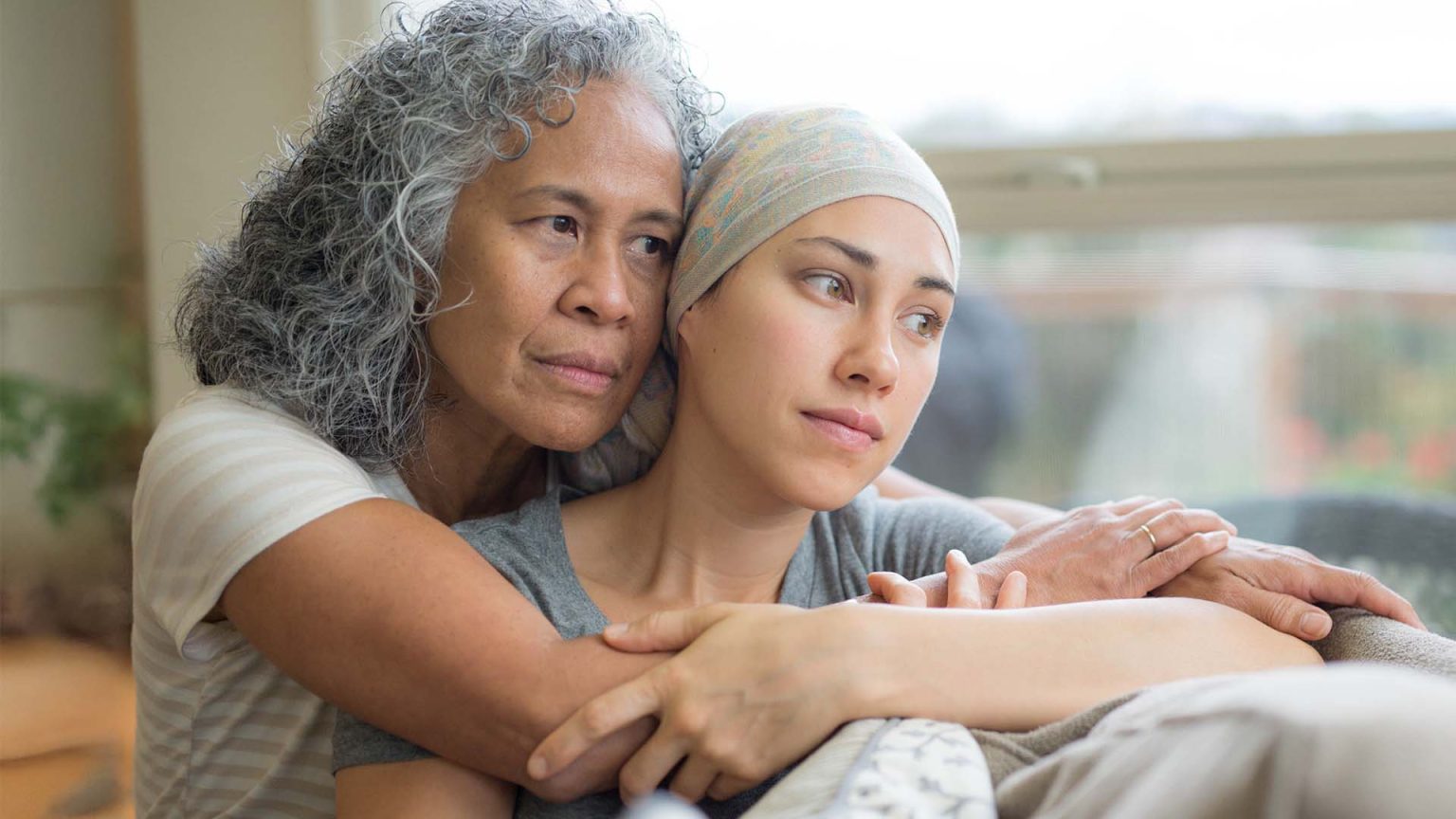 Adult female with cancer being comforted by her mother