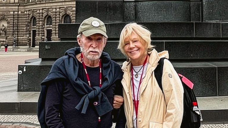 Rick and Val posing before a statue and historic building.